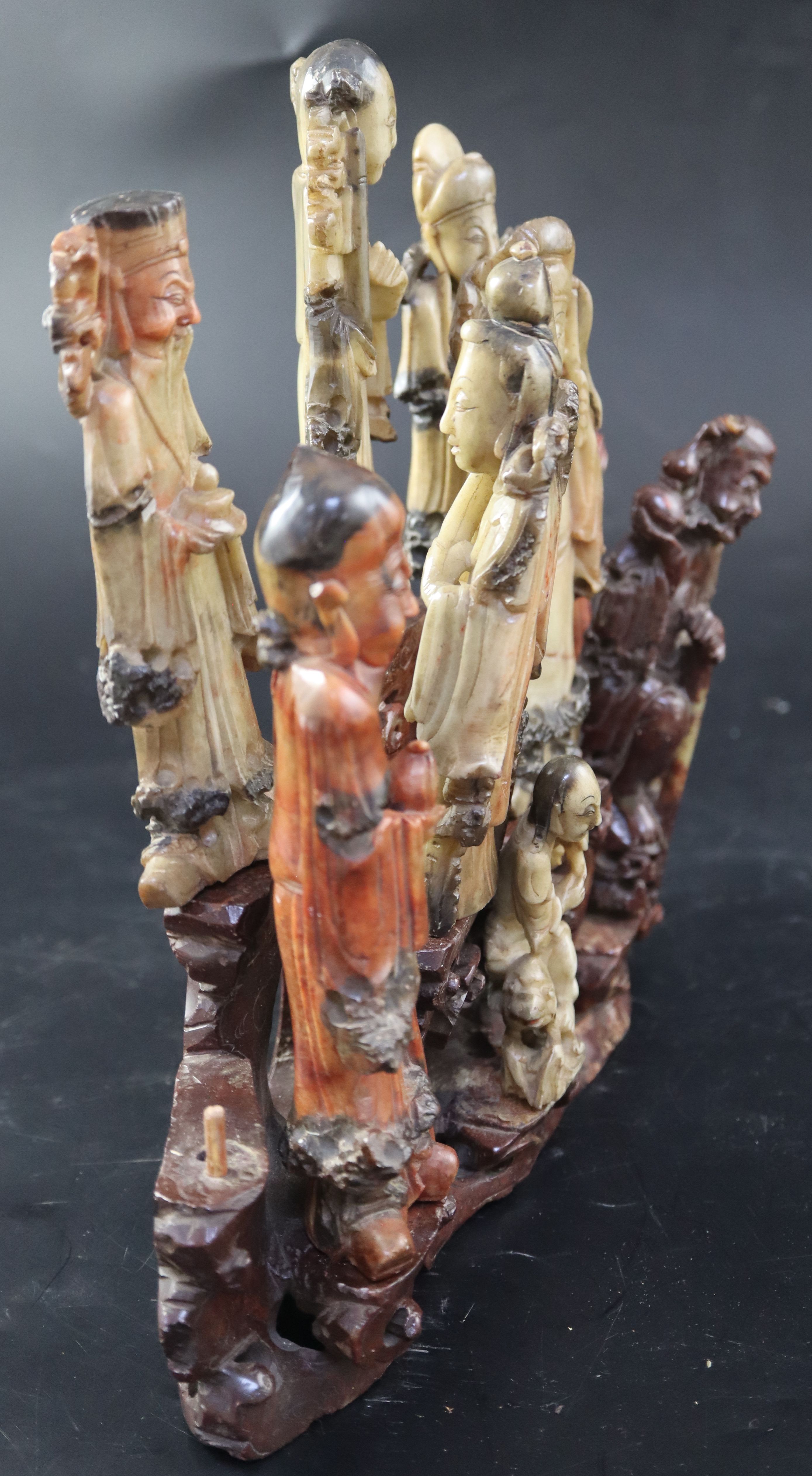 A group of nine Chinese Taoist carved coloured soapstone figures of immortals, width 29cm height 27cm